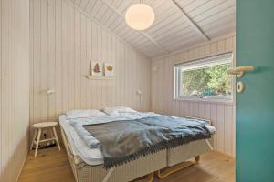 a bedroom with a bed in a room with a window at 1445 Aakirkeby - Poserekrogen 13 in Vester Sømarken
