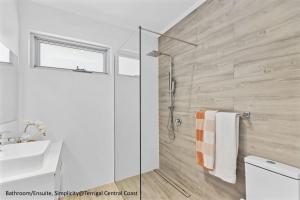 ein Badezimmer mit Dusche, Toilette und Waschbecken in der Unterkunft Simplicity Terrigal in Terrigal + 25 Fotos