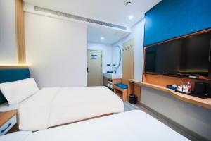 a hotel room with a large white bed and a flat screen tv at 晨雷酒店 in Beijing
