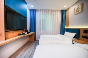 a hotel room with a bed and a flat screen tv at 晨雷酒店 in Beijing