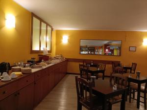 a restaurant with tables and chairs and a long line of counters at Albergo Hotel Giardino in Desio