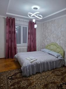 a bedroom with a bed and a ceiling fan at Квартира in Karakol
