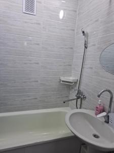 a bathroom with a sink and a bath tub and a sink at Квартира in Karakol