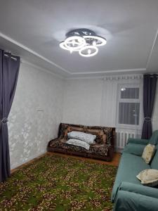a living room with a couch and a chandelier at Квартира in Karakol