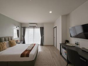 a hotel room with a bed and a flat screen tv at Remas Hotel Hat Yai in Ban Tha Thon