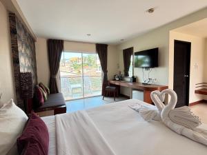 a hotel room with a bed with swans on it at Baramee Resortel in Patong Beach +78 photos