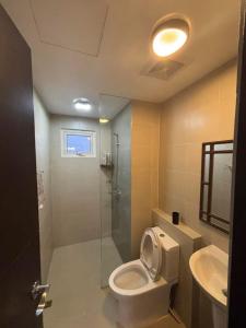 a bathroom with a toilet and a shower and a sink at Okaeri Place - One Regis in Bacolod +11 photos