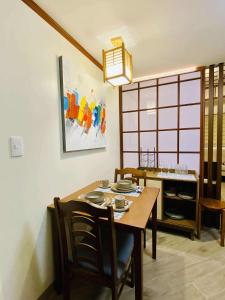 a dining room with a wooden table and chairs at Okaeri Place - One Regis in Bacolod