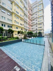 a swimming pool in front of a building at Okaeri Place - One Regis in Bacolod