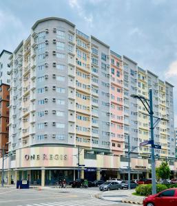 a large apartment building on the corner of a street at Okaeri Place - One Regis in Bacolod