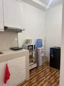 a kitchen with white cabinets and a refrigerator at Kole & Kobe Haven in Dipolog +2 photos