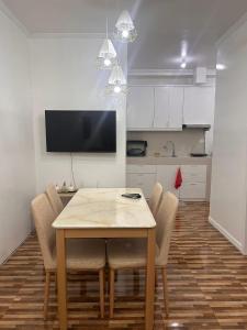 a dining room table with chairs and a kitchen at Kole & Kobe Haven in Dipolog