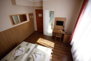 Dormitorio con cama, escritorio y TV en Parti Panzió, en Tata