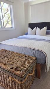 a bedroom with a bed with a wickerasketomaly at Harrington Holiday House in Harrington