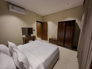 a bedroom with a large white bed and a desk at Tura Residence Al Khaleej- ترى للشقق المخدومة الخليج in Riyadh +2 photos