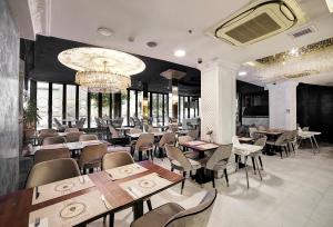 a restaurant with tables and chairs and a chandelier at White Monarch Hotel in Istanbul