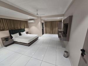 a bedroom with a bed and a television in it at Hotel Shivalik inn in Ankleshwar