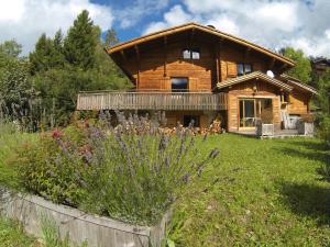 a log cabin with a garden in front of it at Chalet Coelacanthe in La Clusaz