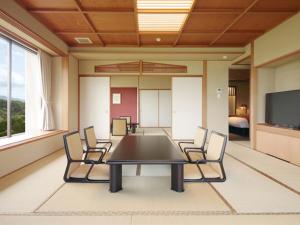 a conference room with a table and chairs and a tv at Jodogahama Park Hotel in Miyako