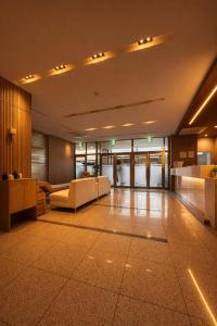 a lobby of a building with couches and tables at 썸원호텔 in Yŏsu