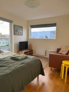 a bedroom with a bed and a couch and a window at Mellbystrand Björkvägen Apartment in Mellbystrand