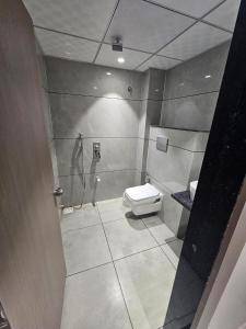 a bathroom with a toilet and a shower at Hotel Shivalik inn in Ankleshwar +7 photos
