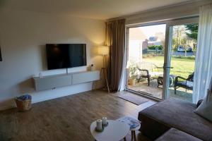 a living room with a flat screen tv on a wall at Ferienwohnung Nordig in Garding