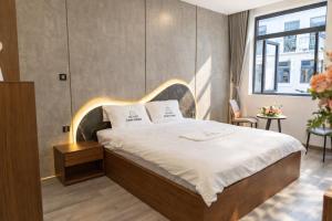 a bedroom with a large bed with a wooden headboard at Vinh Home Apartment in Quang Tri