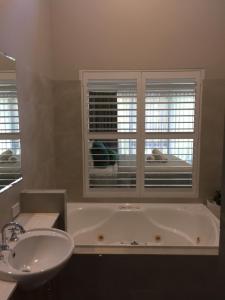 a bathroom with a tub and a sink and a window at Margarets Forest in Margaret River Town +46 photos