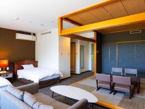 a hotel room with a bed and a living room at Hotel Flags Sasebo KujuKusima in Sasebo