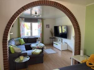 an archway in a living room with a couch at Golfhues-Simone-EG-Appartement-mit-grossem-Garten in Wulfen auf Fehmarn