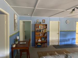a living room with a table and a book shelf at Winganna Farm in Peel +11 photos