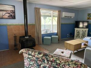 a living room with a couch and a wood stove at Winganna Farm in Peel