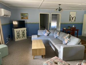 a living room with a couch and a tv at Winganna Farm in Peel
