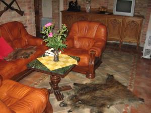 uma sala de estar com duas cadeiras e uma mesa com um vaso de flores em Vila Elvyra em Nida