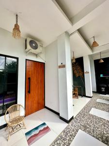 a lobby with a wooden door and a chair at KeJogja Homestay in Grigak
