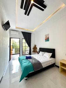 a bedroom with a large bed with a ceiling fan at KeJogja Homestay in Grigak