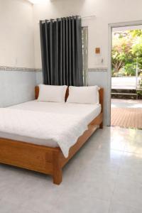 a bed in a room with a window and a bed sidx sidx at Sơn Hiển Homestay in Cam Lâm