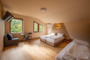 a hotel room with two beds and a chair at Къща за гости Трявна in Tryavna
