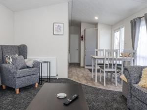 a living room with two chairs and a table at Lazy Daze in Bridlington +8 photos