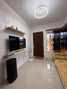 a living room with a couch and a flat screen tv at Private Cozy Home in Tagum