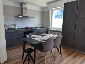 a kitchen with a black table and chairs and a window at Tra prati e monti - Dolomiti Bellunesi in Valle di Cadore +47 photos