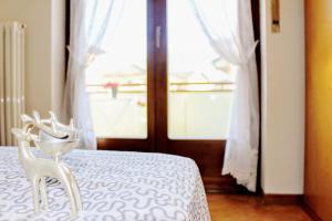 a white chair sitting on a bed in front of a window at Comano Terme Apart in Comano Terme