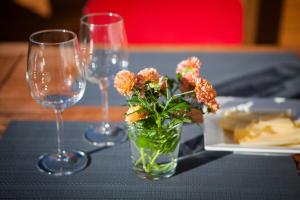 un vase avec des fleurs sur une table et deux verres à vin dans l'établissement Villa Rajala, à Imatra