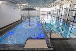 a large swimming pool with a fountain in a building at K&J's Caravan Rental in Kinmel Bay