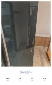 a person standing behind a glass door in a room at Apartament excepțional la casa in Dumbrăviţa