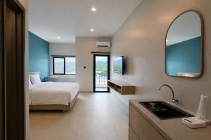 a bedroom with a bed and a sink and a mirror at Bene Residence in Maluk