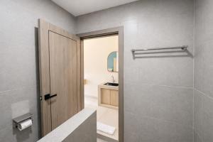 a bathroom with a walk in shower and a door at Bene Residence in Maluk