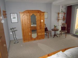 a room with a wooden cabinet with a mirror at Haus-Kummeleck-Wohnung-4 in Bad Lauterberg