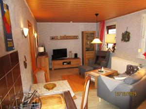 a living room with a couch and a table at Haus-Kummeleck-Wohnung-4 in Bad Lauterberg +4 photos